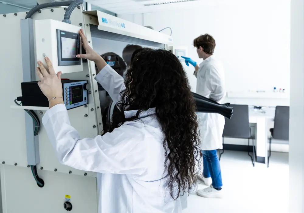 Moksleiviai laboratorijoje dirba su moksline įranga, rengdami tiriamuosius darbus.